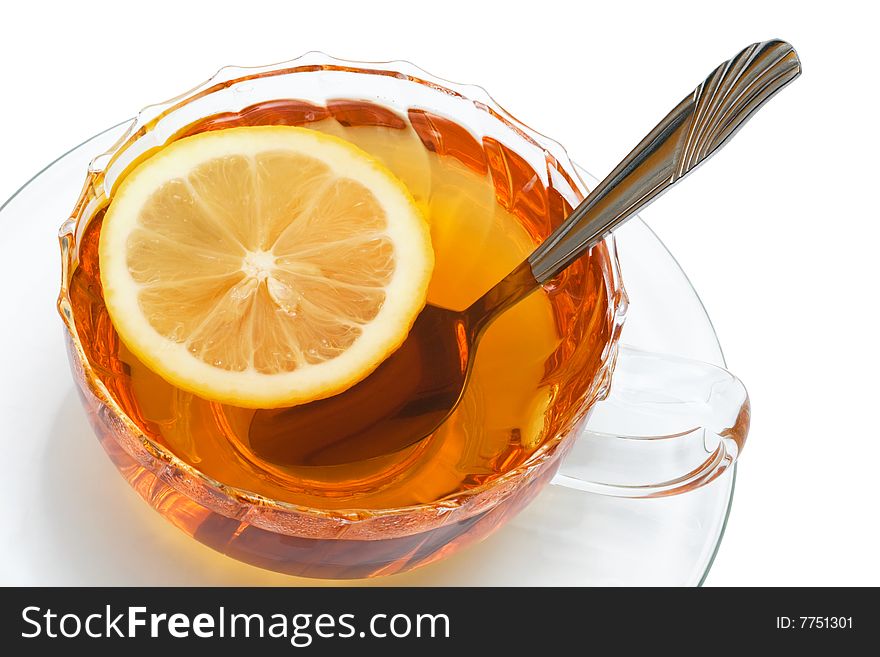 Glass cup with tea and a lemon on a white background
