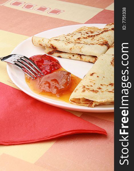 Plate of tasty pancakes with jam on the table