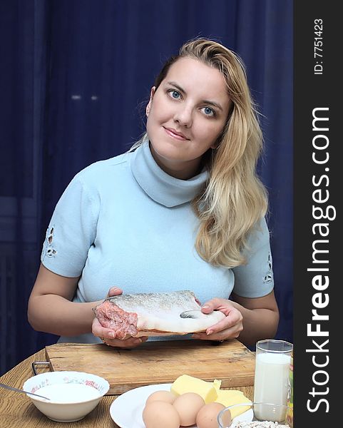 Woman on kitchen makes a fish for a dinner. Woman on kitchen makes a fish for a dinner