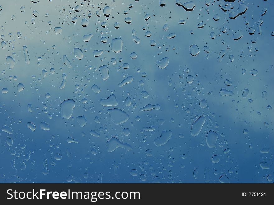 Water drops on a roof window, behind sky