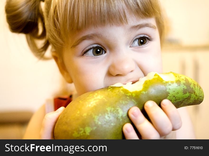 Portrait of the little girl biting the big green pear. Portrait of the little girl biting the big green pear.