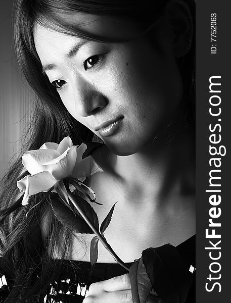 Black and White photograph of a japanese woman holding a rose. Black and White photograph of a japanese woman holding a rose.