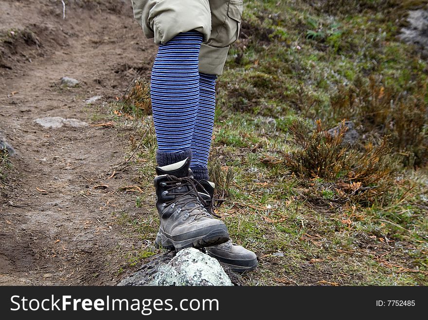 A hikers legs and boots with funny socks. A hikers legs and boots with funny socks