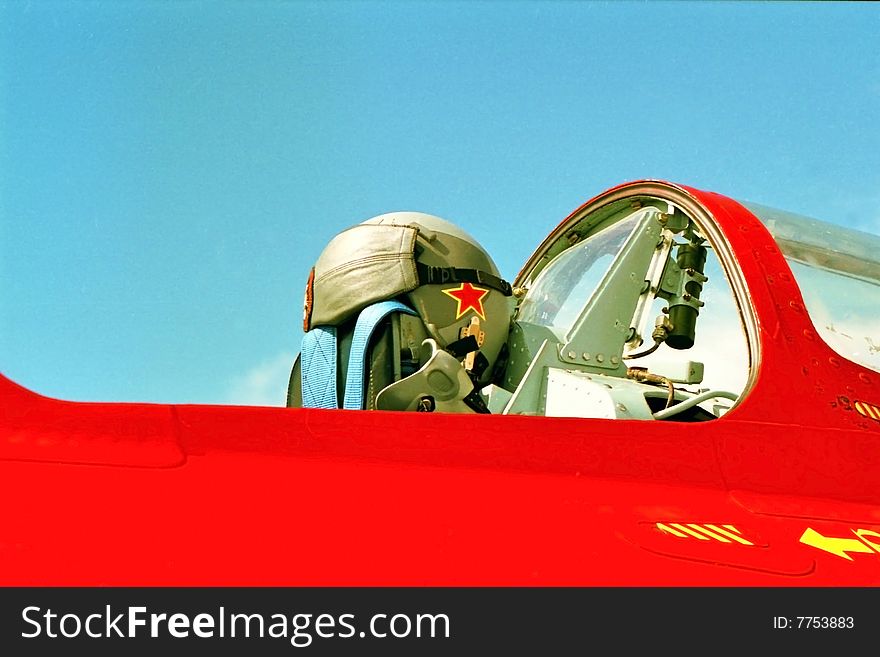 The cockpit of a Russian MIG with the pilots helmet resting on the seat.