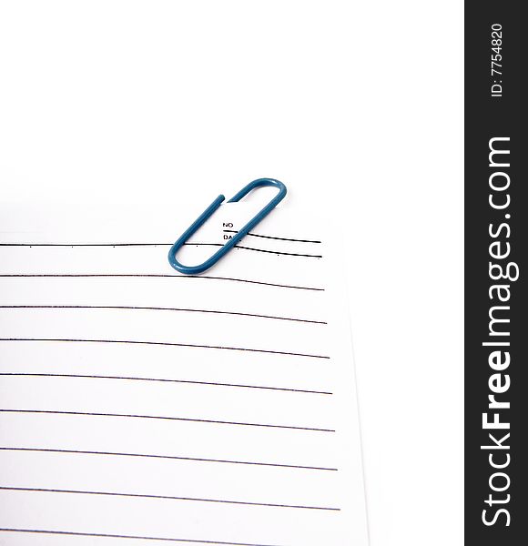 Sheet of notepad with blue paperclip on a white background. Sheet of notepad with blue paperclip on a white background