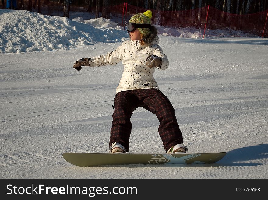 Snowboard girl on the slope in winter.