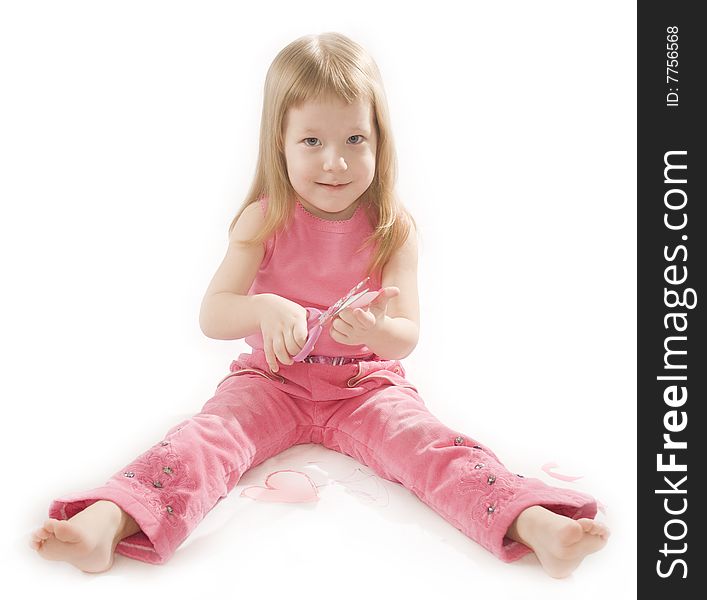 Pretty small girl is cutting paper heart shape