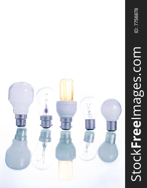 A row of assorted bulb with a lighted energy bulb central. A row of assorted bulb with a lighted energy bulb central