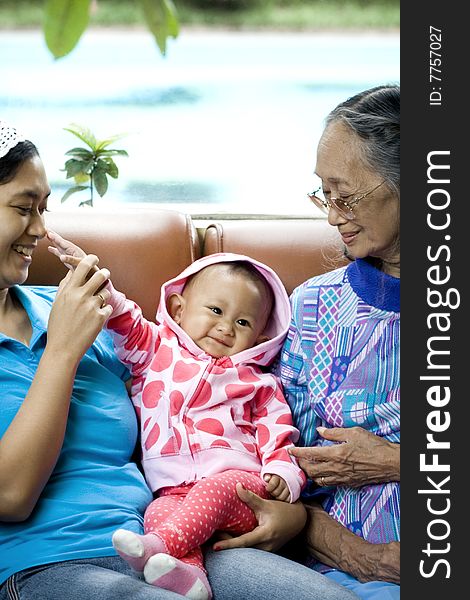 Photo of 3 generation women: a baby, mom and grandma having a good time together - happy family. Photo of 3 generation women: a baby, mom and grandma having a good time together - happy family