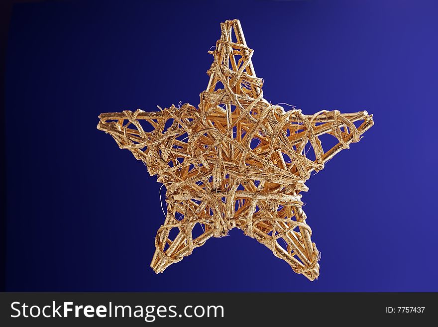The gold Christmas ornament isolated on a dark blue background. The gold Christmas ornament isolated on a dark blue background.