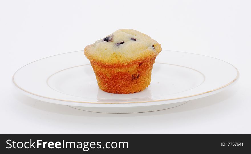 A blueberry muffin on plate, isolated on white