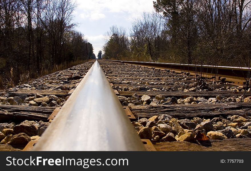 Looking down the rail of a railroad track.  Cross ties and gravel are visible. Looking down the rail of a railroad track.  Cross ties and gravel are visible.