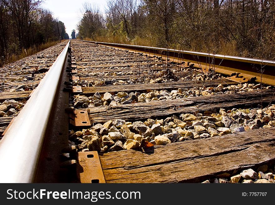 Looking down the rail of a railroad track.  Cross ties and gravel are visible. Looking down the rail of a railroad track.  Cross ties and gravel are visible.