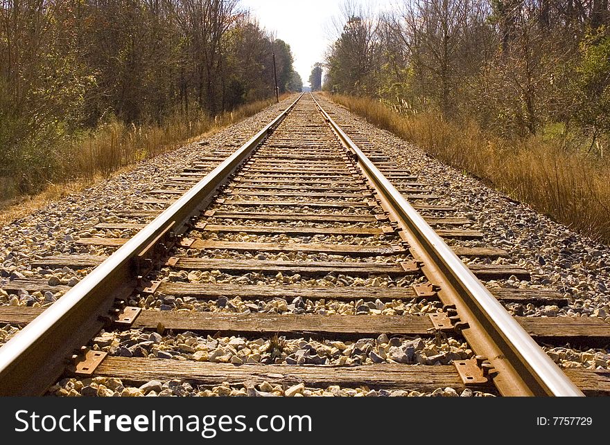 Looking down the rail of a railroad track. Cross ties and gravel are visible. Looking down the rail of a railroad track. Cross ties and gravel are visible.