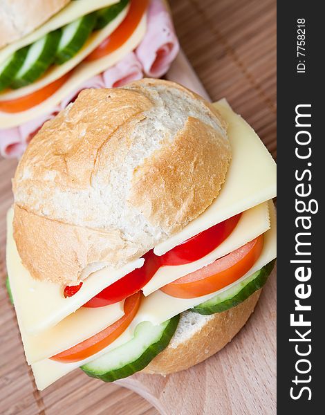 Delicious ham, cheese and salad sandwich on a wooden board