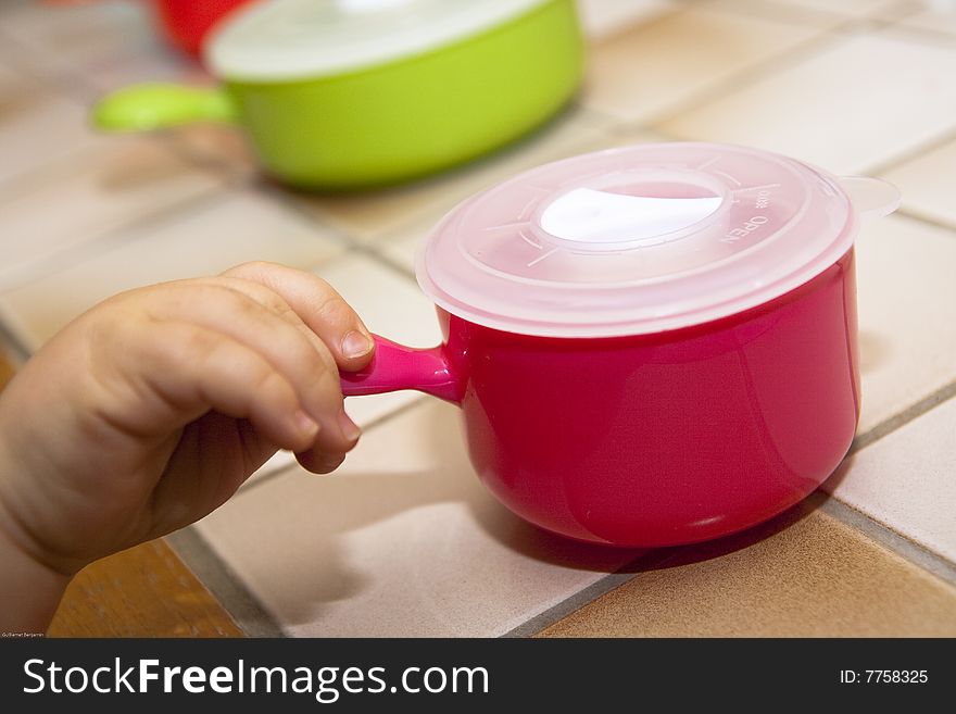 Baby's hand taking a food pot alone