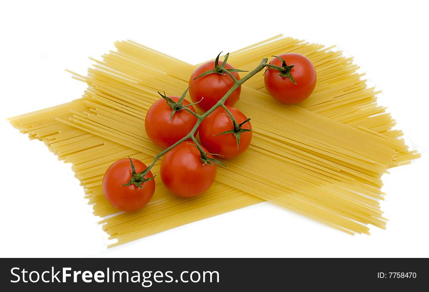 Branch of tomatoes lies on macaroni. Branch of tomatoes lies on macaroni