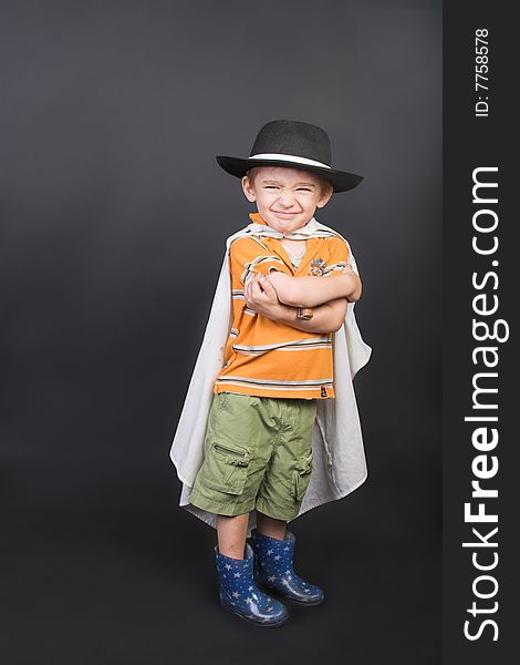 Young boy playing dressed up in hat and cape. Young boy playing dressed up in hat and cape