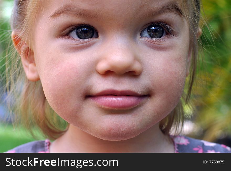 Little girl pulling funny faces and making the sound of a car