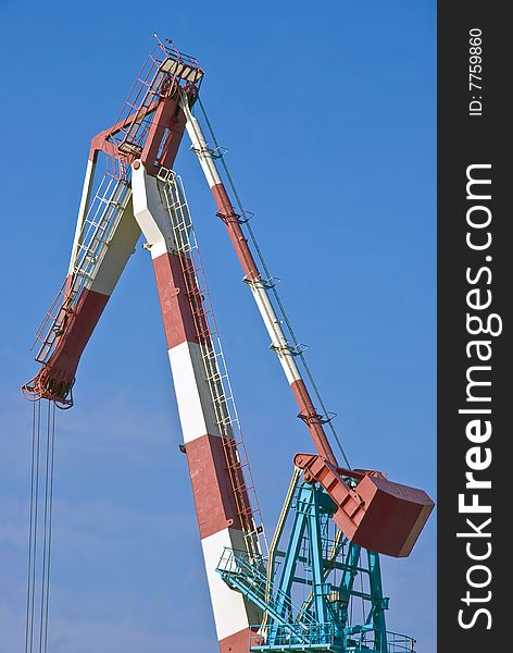 Heavy industrial crane used to load and unload large cargo ships at a port. Heavy industrial crane used to load and unload large cargo ships at a port