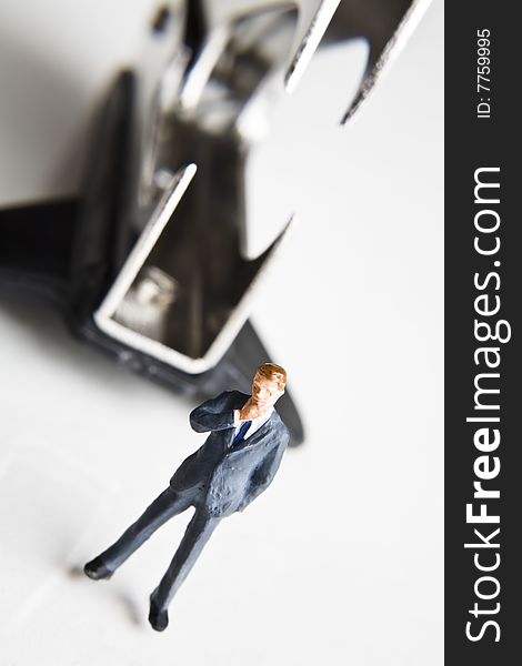 Business figurine placed with a staple remover. Business figurine placed with a staple remover