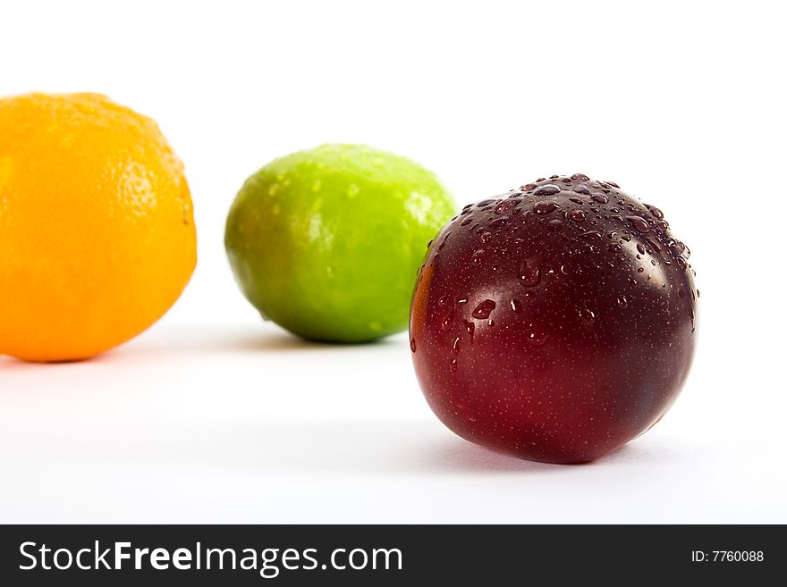 Orange, lemon, apple and plum on white background