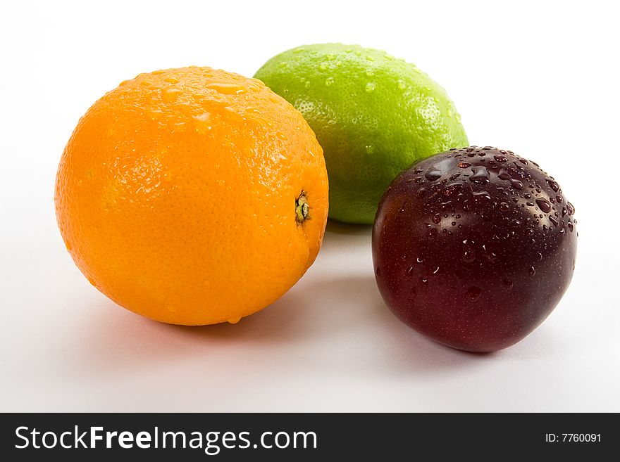 Lemon, orange and plum on white background