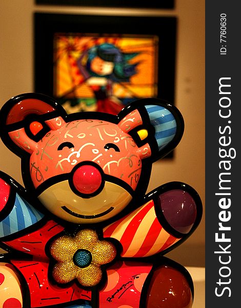A colorful teddy bear in a art gallery