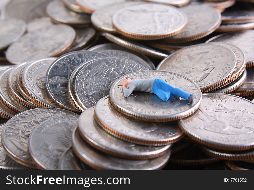 Miniature man sleeping on pile of quarters. Miniature man sleeping on pile of quarters