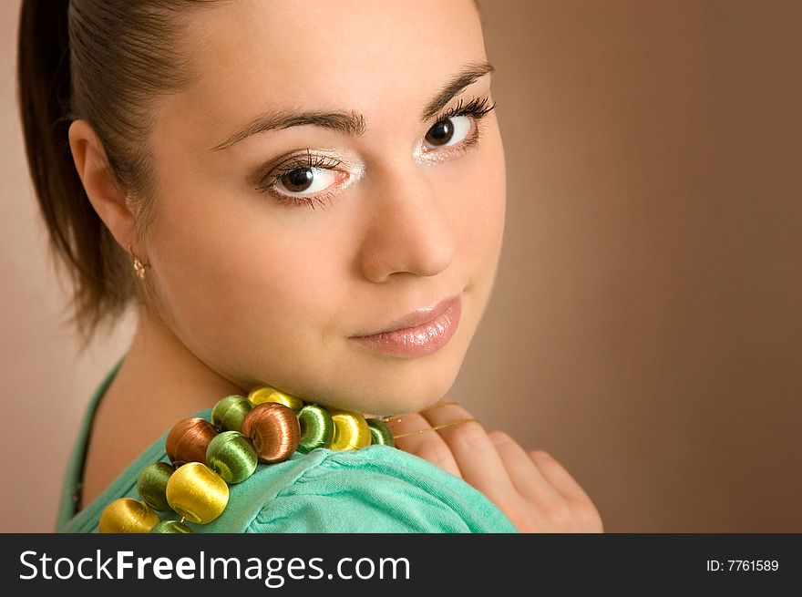 The beautiful young woman with a beads in a hand