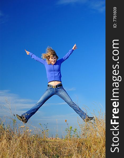 The girl jumps in the field against the sky. The girl jumps in the field against the sky