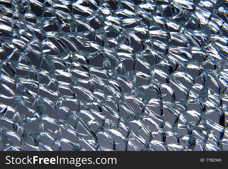 Broken tempered glass texture at grey background