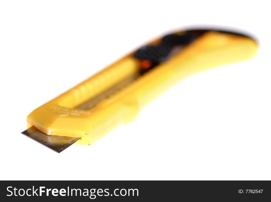 Sharp retractable utility knife with yellow plastic handle. Isolated on the white background. Narrow depth of field. Sharp retractable utility knife with yellow plastic handle. Isolated on the white background. Narrow depth of field.