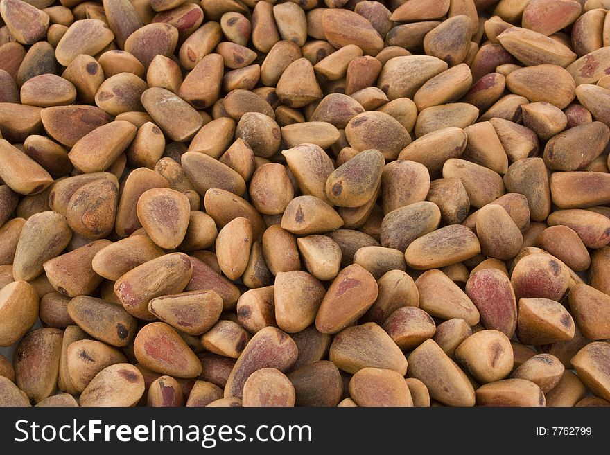 Many the crude pine nuts, on background