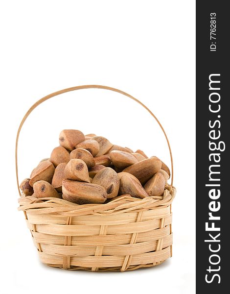 The crude pine nuts in a basket on a white background