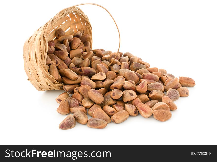 The crude pine nuts in a basket on a white background