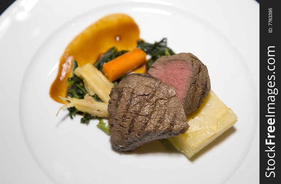 A gourmet plate with beef meat cheese carrots and vegetables