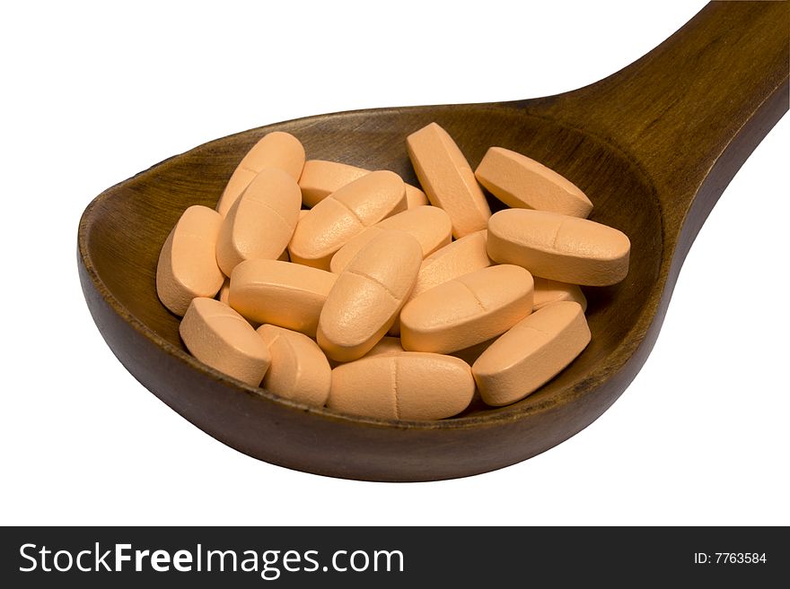 Pills in a wooden brown spoon on a white background it is isolated. Pills in a wooden brown spoon on a white background it is isolated