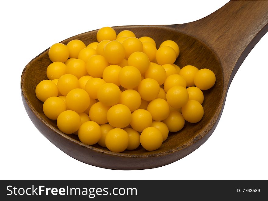 Pills in a wooden brown spoon on a white background it is isolated. Pills in a wooden brown spoon on a white background it is isolated