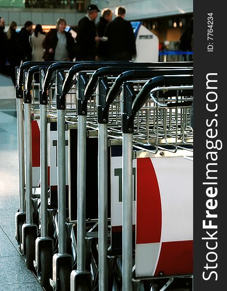 Trolleys in a row in front of passengers at an airport