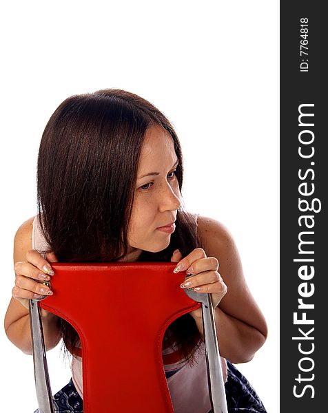 Dark haired young woman is sitting on the read modern chair. Dark haired young woman is sitting on the read modern chair