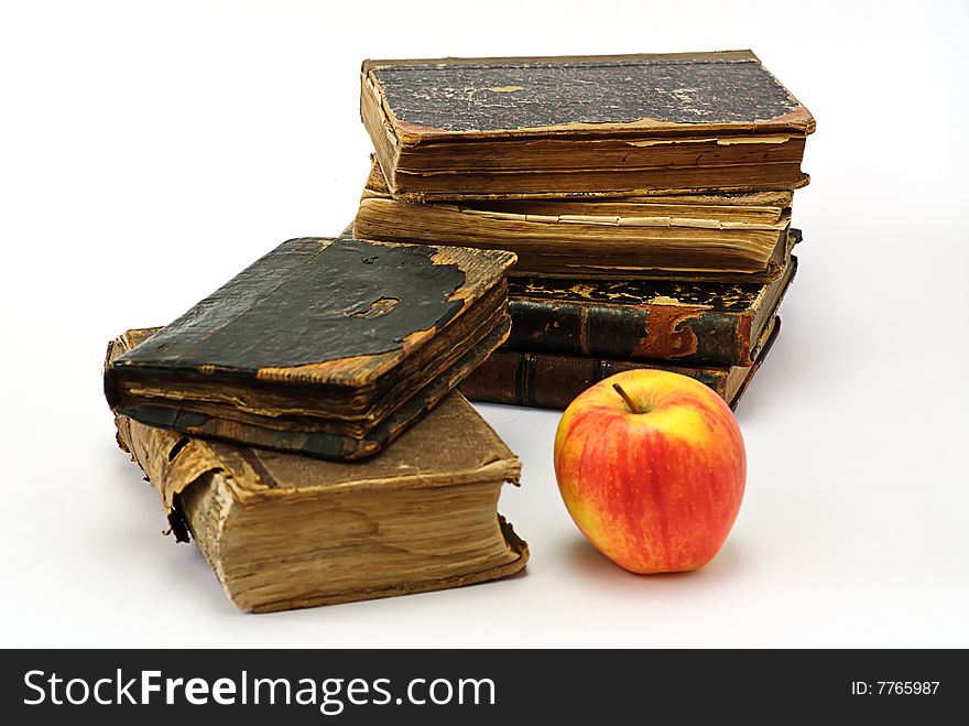 Old  religious books and apple on white. Old  religious books and apple on white