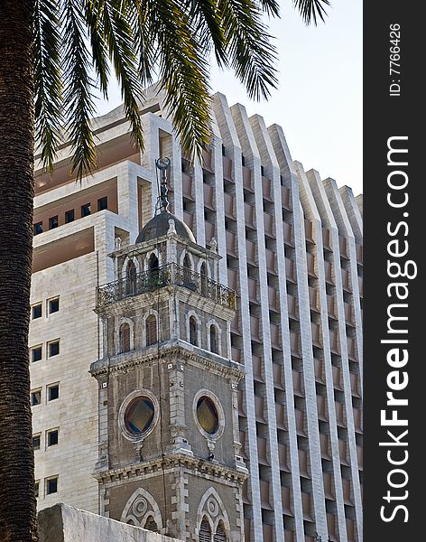 Old minaret on the high modern building background in Haifa city. Old minaret on the high modern building background in Haifa city.