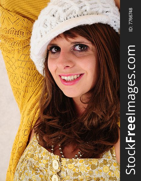 Lovely head shot of a female in a white knitted hat. Lovely head shot of a female in a white knitted hat