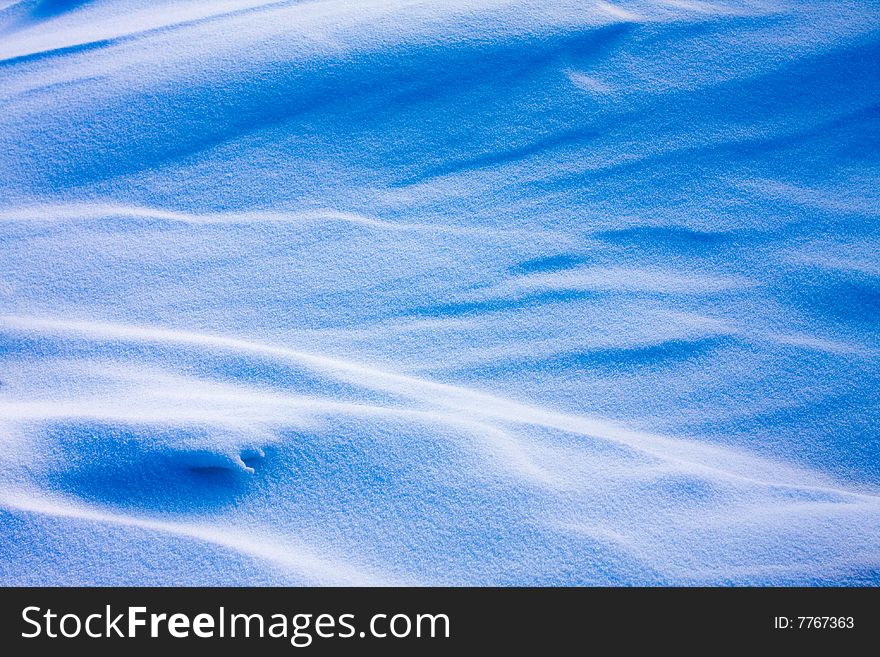 Shadow and light on the snowfield in a cold day