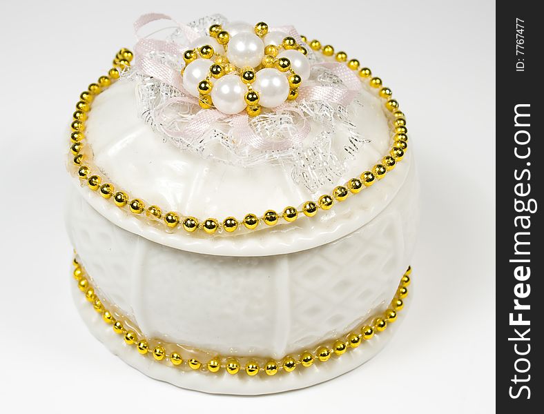 White round box with costume jewellery and ornaments