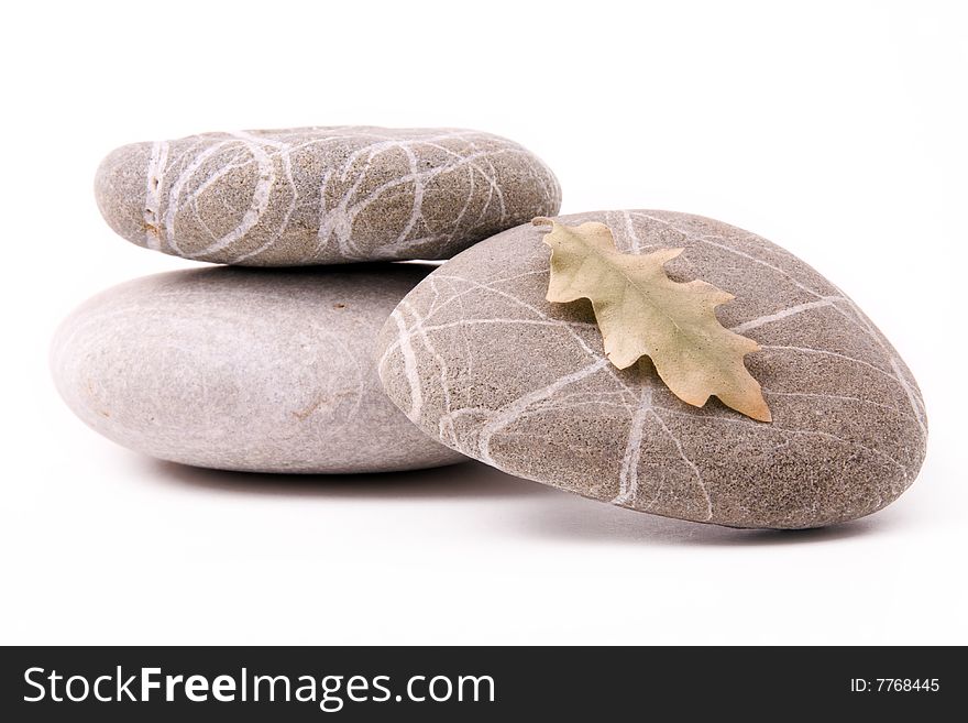 Stones with dry leaf on a white background