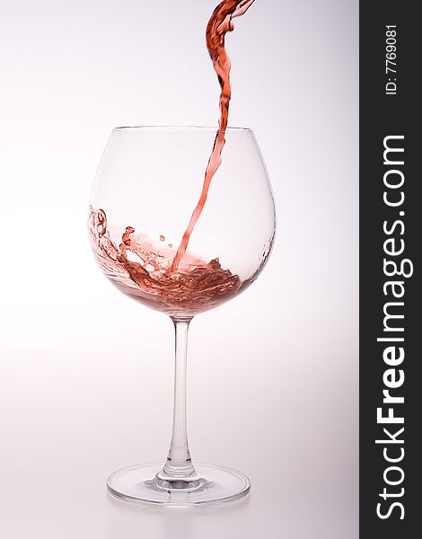 Red wine flow in a transparent glass