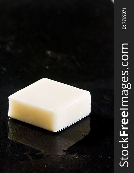 Bar of white soap on wet black slate