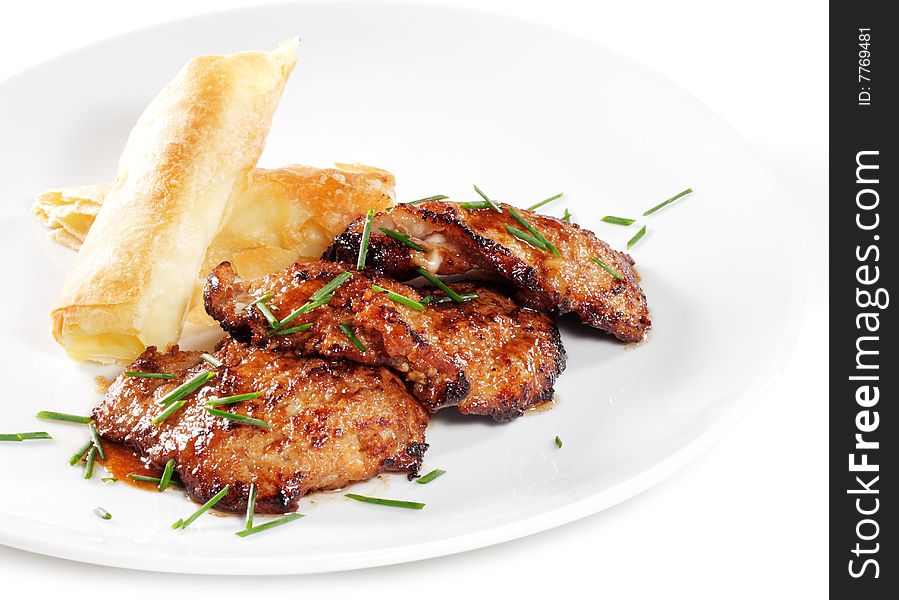 Roasted Pork with Rolled Up Potato and Greens Isolated on White Background. Roasted Pork with Rolled Up Potato and Greens Isolated on White Background